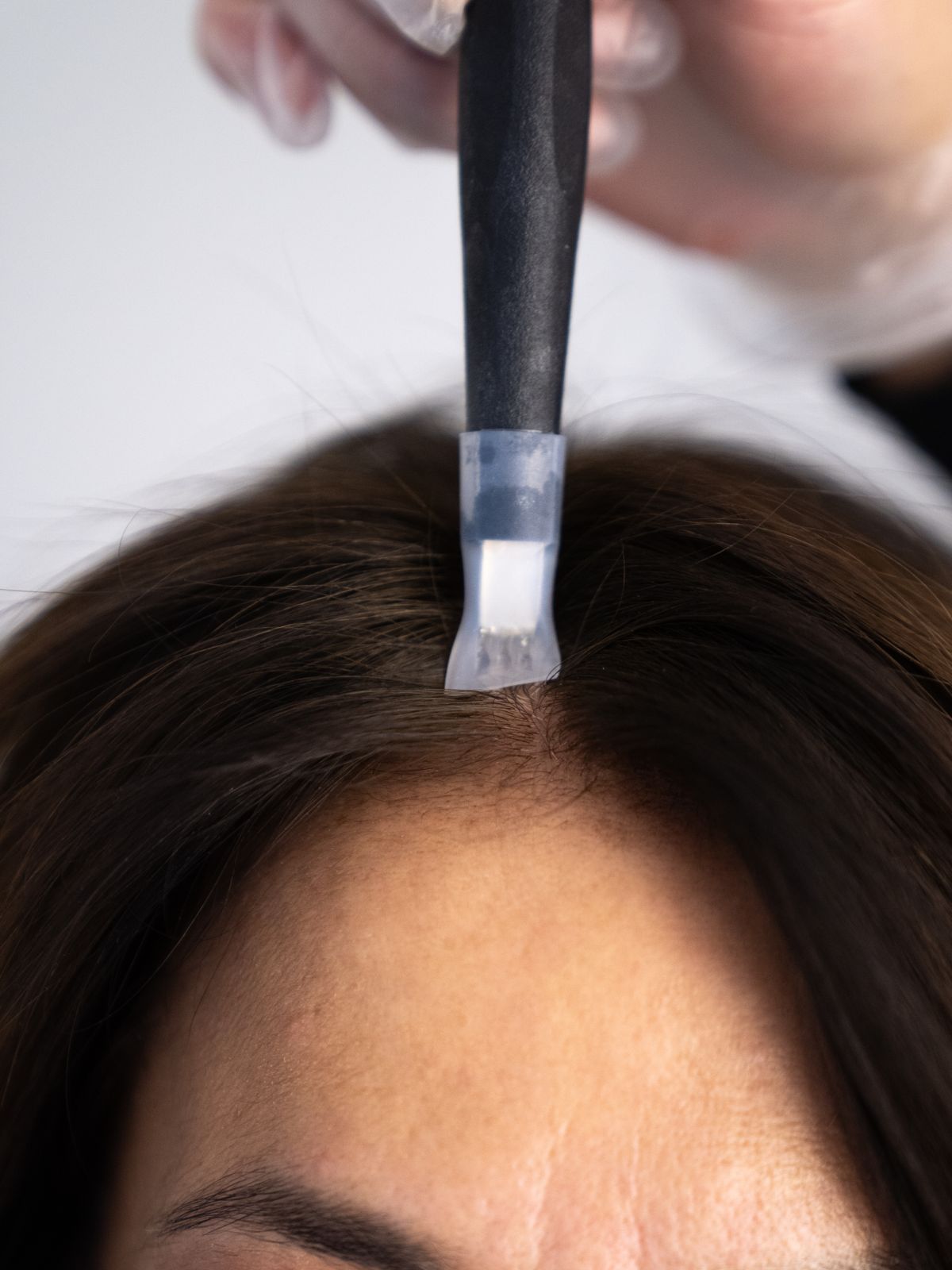 Soin REYU cheveux appliqué raie par raie sur le cuir chevelu